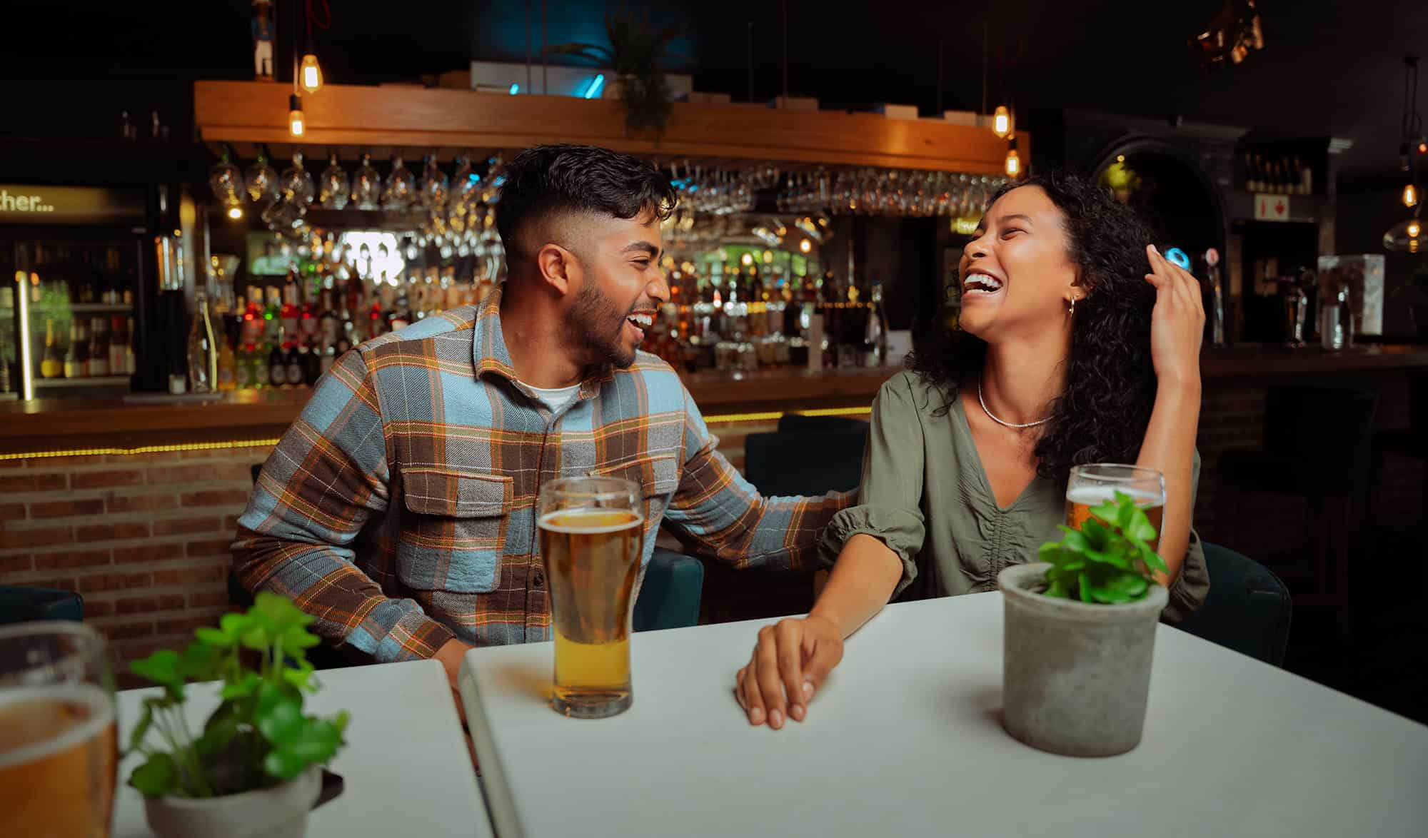 diverse couple of friends out for drinks laughing